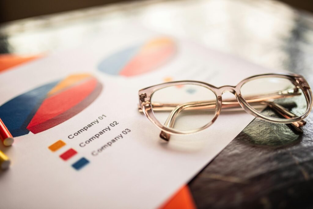 pexels-photo-7948004-7948004 Close-up of eyeglasses on a table with colorful business charts.